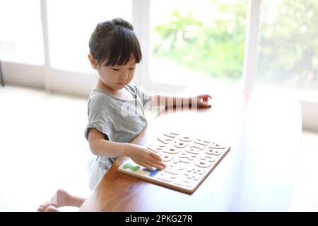 Ragazza che fa puzzle alfabeto Foto Stock