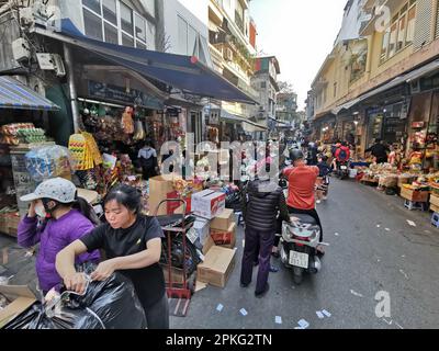 Hanoi, Vietnam. 26th Feb, 2023. Persone e ciclomotori si animano in una strada commerciale nel quartiere Vecchio Credit: Alexandra Schuler/dpa/Alamy Live News Foto Stock