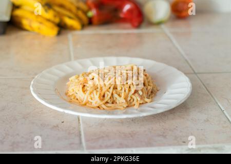 porzione di spaghetti con stufato servita su un piatto bianco Foto Stock