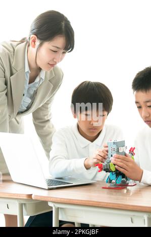 Uno studente di scuola elementare che impara la programmazione dal suo insegnante Foto Stock