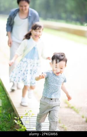 Genitori e bambini che giocano nel parco Foto Stock