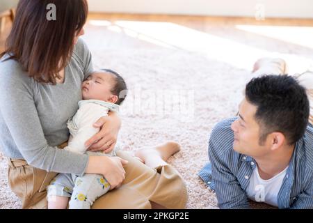 Famiglia che guarda il bambino che dorme Foto Stock