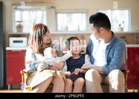 La famiglia si siede sul divano chiacchierando Foto Stock