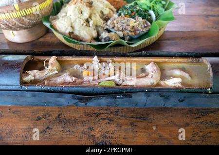 Garang asem, un cibo tradizionale indonesiano, delizioso pollo cotto in bambù bruciato Foto Stock