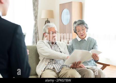 Coppia senior che parla con un uomo d'affari Foto Stock