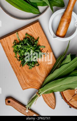 Aglio selvatico. Aglio selvatico su un asse di legno su un tavolo. Foto Stock