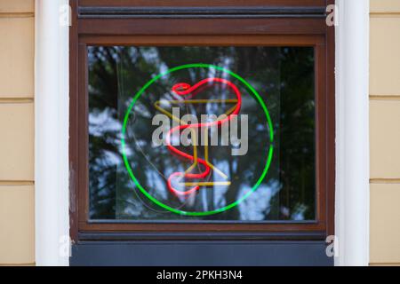 Primo piano su una luce verde al neon a forma di Bowl of Hygieia sopra una farmacia a Wroclaw, Polonia. Foto Stock