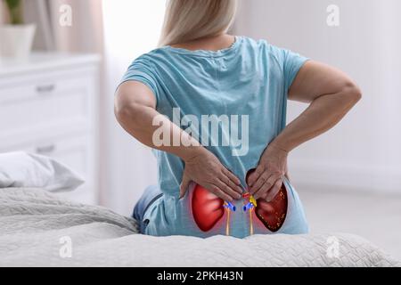 Donna anziana che soffre di dolore renale a casa, primo piano Foto Stock