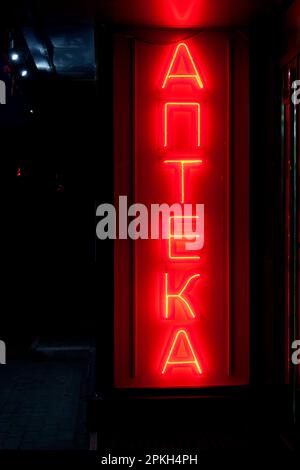 Luce rossa al neon modellata nella parola russa 'АПТЕКА', che significa in inglese 'FARMACIA'. Foto Stock