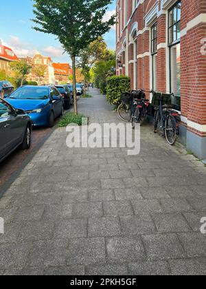 Splendida vista sulla strada della città con case moderne, biciclette e auto parcheggiate Foto Stock