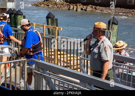 L'equipaggio del traghetto assicura la barca mentre un ranger del parco accoglie i visitatori del Fort Sumter National Monument a Charleston, South Carolina, USA Foto Stock