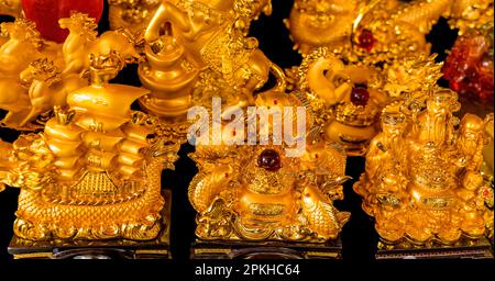 Statue d'oro nave di pesce studiosi cinesi mercato dell'artigianato Tempio buddista Wat Ratchanadbaram Bangkok Thailandia. Foto Stock