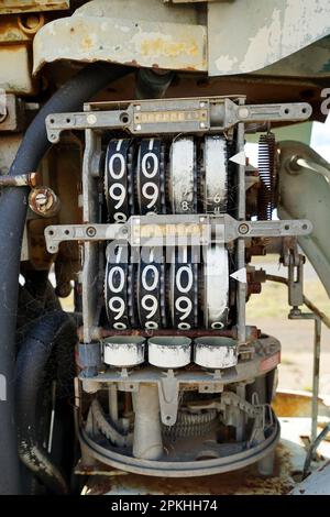 Vista dettagliata che mostra i quadranti dei prezzi con i numeri all'interno di una pompa di erogazione carburante d'epoca presso una stazione di servizio abbandonata. Foto Stock