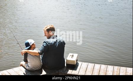 Pesca andata. Vista posteriore ripresa di un padre e suo figlio che pescano insieme. Foto Stock