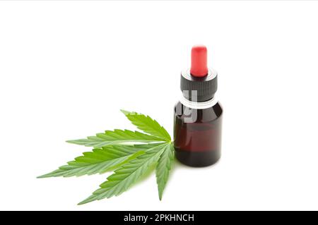 Olio di canapa e foglia di cannabis isolati su sfondo bianco. Olio di cannabis sano. Vista dall'alto Foto Stock