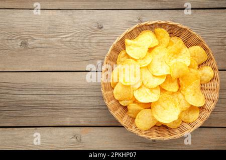 Patatine in cestino su sfondo grigio di legno. Vista dall'alto Foto Stock