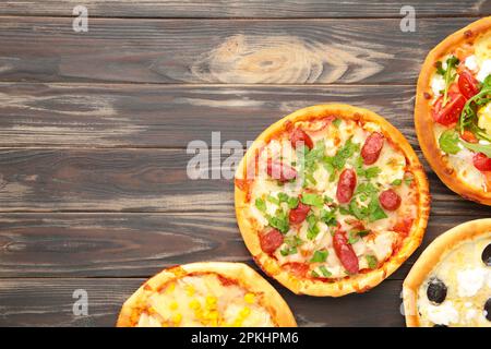 Varietà di pizze su sfondo di legno marrone. Vista dall'alto Foto Stock