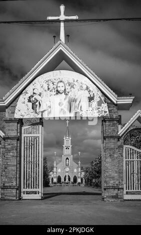 Il cancello d'ingresso alla chiesa cattolica di Hoang Yen a Chu prong, provincia di Gia Lai, Vietnam. Lo slogan sopra la porta recita 'Gesù è primavera (stagione)' Foto Stock