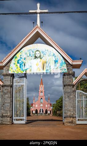 Il cancello d'ingresso alla chiesa cattolica di Hoang Yen a Chu prong, provincia di Gia Lai, Vietnam. Lo slogan sopra la porta recita 'Gesù è primavera (stagione)' Foto Stock