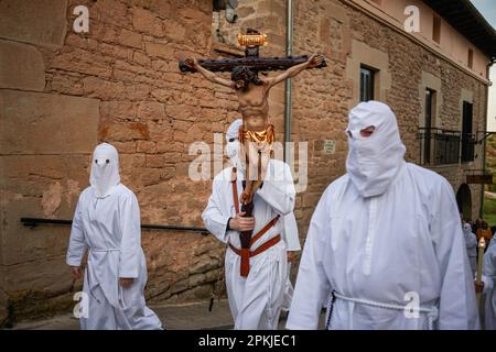 Un penitente della Confraternita della Santa de la vera Cruz porta una croce di Gesù Cristo attraverso le strade di Torres del Río, Navarra, Spagna. La Confraternita di Santa de la vera Cruz celebra una caratteristica processione nella settimana Santa a Torres del Río, Navarra, Spagna, nella quale i penitenti sono vestiti di bianco, facendo una piccola parte del Camino de Santiago, In cui portano una croce che un penitente rompe il silenzio della notte battendo al suono delle orme, mentre altri membri della fraternità portano la Virgen de la dolorosa. (Foto di Elsa A Bravo/SOPA Image Foto Stock