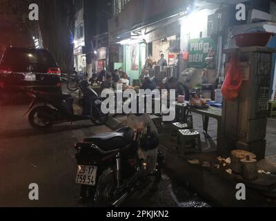 Hanoi, Vietnam. 26th Feb, 2023. Persone sedute sul marciapiede di fronte a un ristorante sulla strada. Credit: Alexandra Schuler/dpa/Alamy Live News Foto Stock