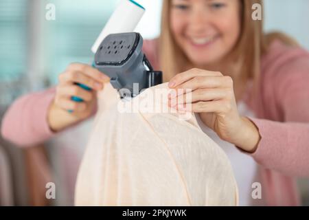 casalinga che sostituisce il sacchetto dell'aspirapolvere Foto Stock