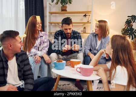 Divertendoti. Gruppo di amici hanno partito insieme all'interno. Foto Stock