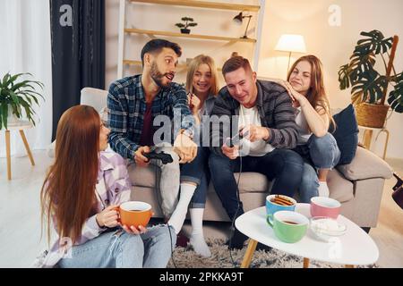 Riproduzione di un videogioco. Gruppo di amici hanno partito insieme all'interno. Foto Stock