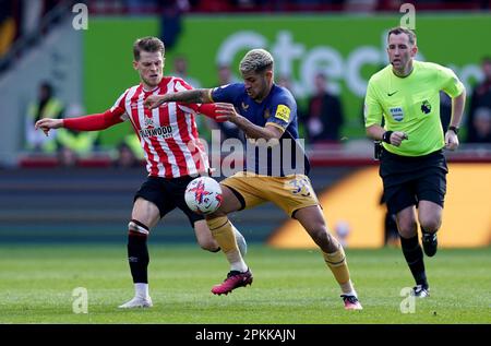 Bruno Guimaraes del Newcastle United batte con Mathias Jensen di Brentford durante la partita della Premier League al GTECH Community Stadium, Londra. Data immagine: Sabato 8 aprile 2023. Foto Stock