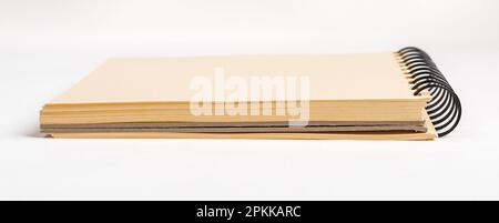 Schedario, schedario con rilegatura a spirale con fogli bianchi di carta gialla vista laterale. Foto Stock