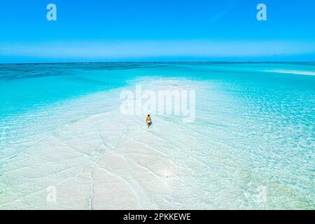 Veduta aerea della donna che fa il bagno nel mare trasparente nei banchi di sabbia panoramici, Nungwi, Zanzibar, Tanzania, Africa orientale, Africa Foto Stock