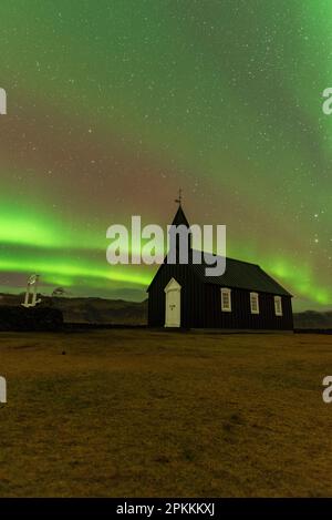L'iconica chiesa di Budakirkja in legno nero sotto l'aurora boreale, Budir, Penisola della Snaefelsness, Vesturland, Islanda, Regioni polari Foto Stock