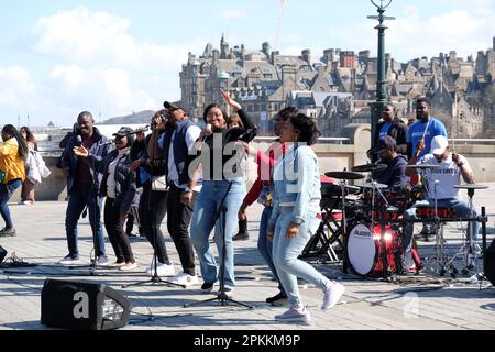 Edimburgo, Scozia, Regno Unito. 8th aprile 2023. RCCG Edinburgh Tabernacle choir cantare con gusto e divertimento vacanzieri e visitatori al Mound sullo sfondo dei tetti della Città Vecchia. Credit: Craig Brown/Alamy Live News Foto Stock