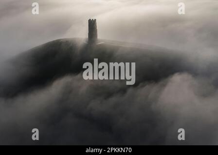 Vista aerea di St. Michael's Tower su Glastonbury Tor circondato da un mare di nebbia in inverno, Glastonbury, Somerset, Inghilterra, Regno Unito, Europa Foto Stock