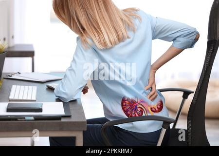 Donna che soffre di dolore renale in ufficio Foto Stock