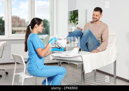 Bella intersuola ortopedica femminile che si adatta al piede del paziente in ospedale Foto Stock