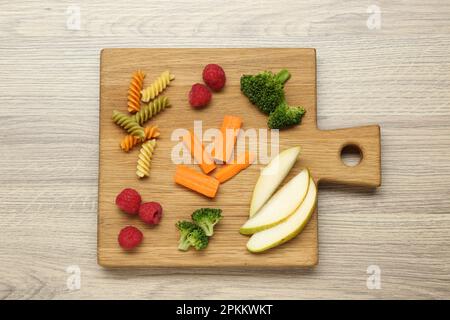 Tavola con diversi gustosi stuzzichini per il bambino su un tavolo di legno, vista dall'alto Foto Stock