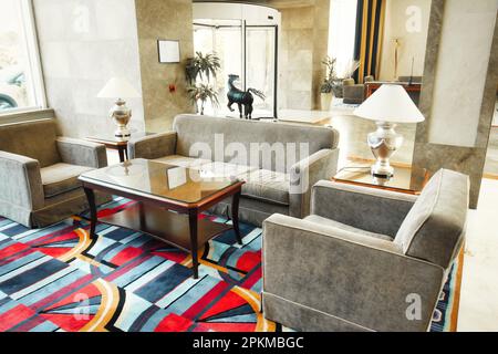 Una lobby di un elegante hotel a 5 stelle con comodi divani e sedie con pavimento e pareti in marmo Foto Stock
