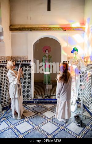 Due turisti scattano una foto ad una mostra di moda al Palazzo Bahia a Marrakech, Marocco Foto Stock