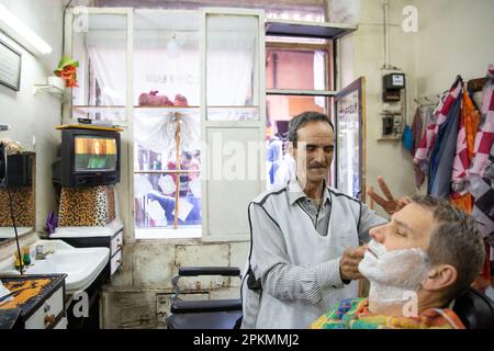 Un turista americano che ottiene un rasoio diritto in un barbiere a Marrakech Marocco Foto Stock