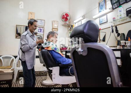 Un turista americano ottenere un taglio di capelli in un barbiere a Marrakech Marocco Foto Stock