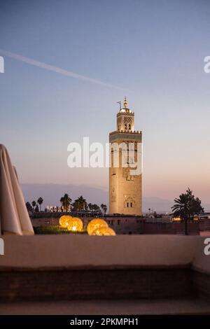 Vista serale della Moschea di Koutoubia dal bar sul tetto dell'hotel El Fenn a Marrakech, Marocco Foto Stock