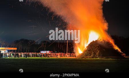 Haltern, 08th Apr, 2023. Centinaia di persone si sono alzate per guardare un grande falò pasquale acceso su un campo a Prickingshof Farm vicino Haltern, NRW. Il falò è strettamente sorvegliato dai vigili del fuoco locali che hanno preparato il fuoco con attenzione, con diversi motori antincendio presenti mentre bambini e adulti guardano. I falò pasquali sono una tradizione cristiana centenaria in Germania, e di solito sono accesi il sabato di Pasqua o la domenica sera. (Esposizione lunga) Credit: Imageplotter/Alamy Live News Foto Stock