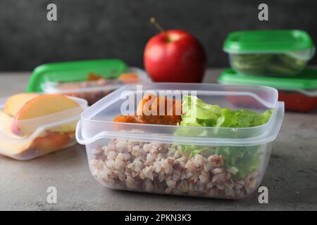 Set di contenitori in plastica con alimenti freschi su tavolo grigio chiaro Foto Stock