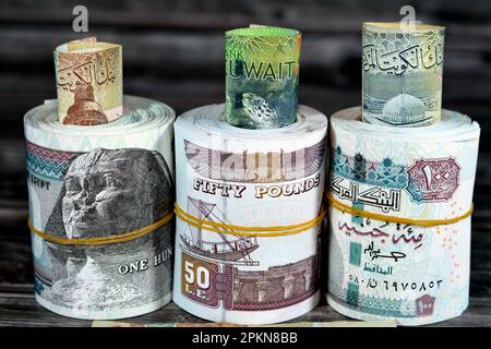 Rotoli di denaro egiziano banconote da 100 e 50 EGP LE cento dinari egiziani e cinquanta sterline e kuwait KWD uno, mezzo e quarto di valuta n Foto Stock