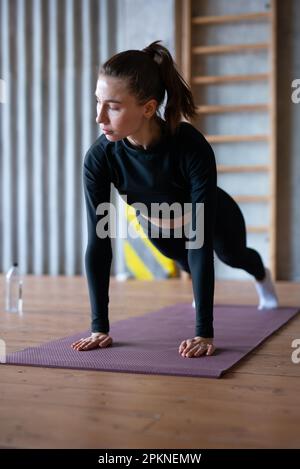 Fit donna che fa pieno asse esercizio opere sui muscoli addominali. Foto Stock