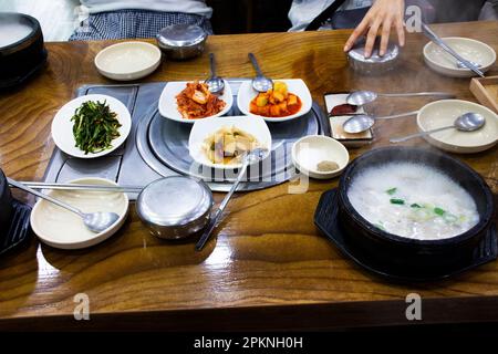 Cucina gourmet tradizionale coreana locale, cibo di strada costolette di maiale zuppa di riso porridge con contorno di condimento per i viaggiatori coreani visita a. Foto Stock