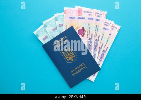 Passaporto ucraino e denaro. Passaporto biometrico di un cittadino ucraino e banconota da 200. Vista dall'alto Foto Stock