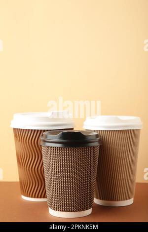 Tre tazze di caffè marrone su sfondo beige. Vista dall'alto Foto Stock