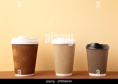 Tre tazze di caffè marrone su sfondo beige. Vista dall'alto Foto Stock